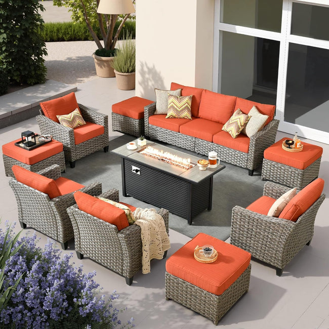 Outdoor patio furniture set with orange cushions and a fire pit table.