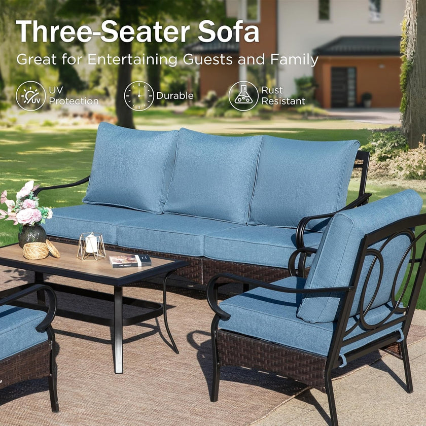 Outdoor furniture set with blue cushions on a patio, featuring a three-seater sofa and armchair.