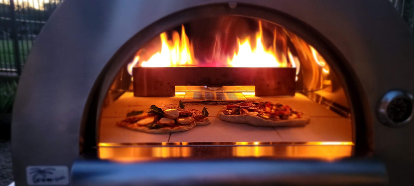 Wood-fired pizza oven with pizzas inside, glowing flames visible