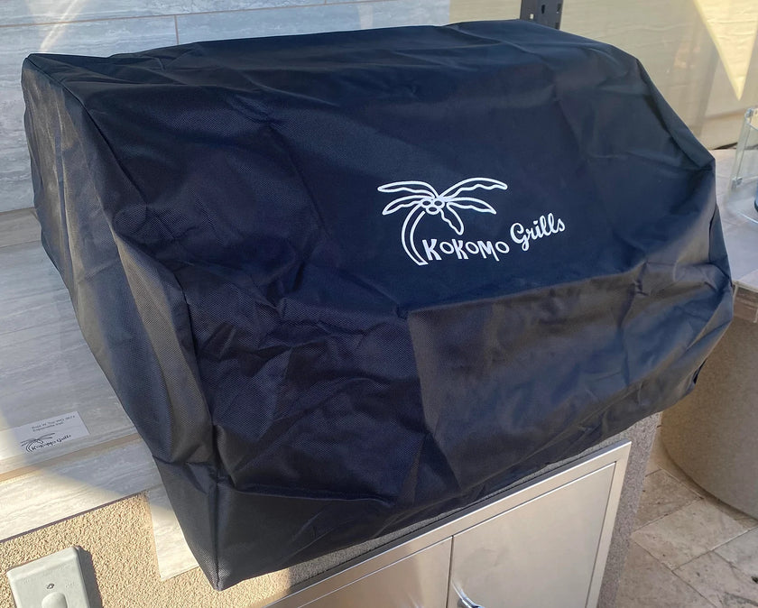 Black grill cover with 'Kokomo Grills' logo on a patio setting