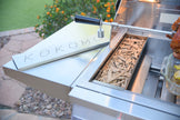 Outdoor grill with wood chips and 'Kokoma' branding on a patio
