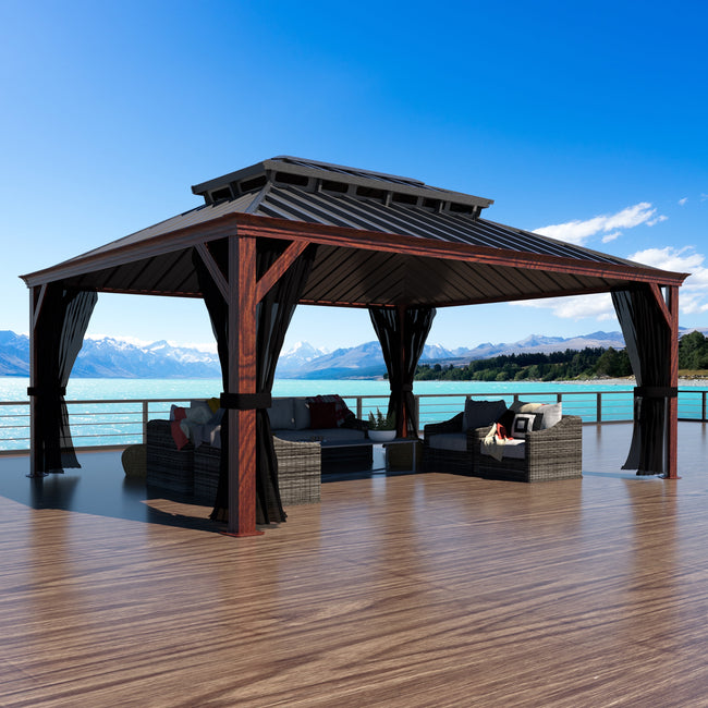Wooden gazebo with outdoor furniture on a deck overlooking a scenic lake and mountains.
