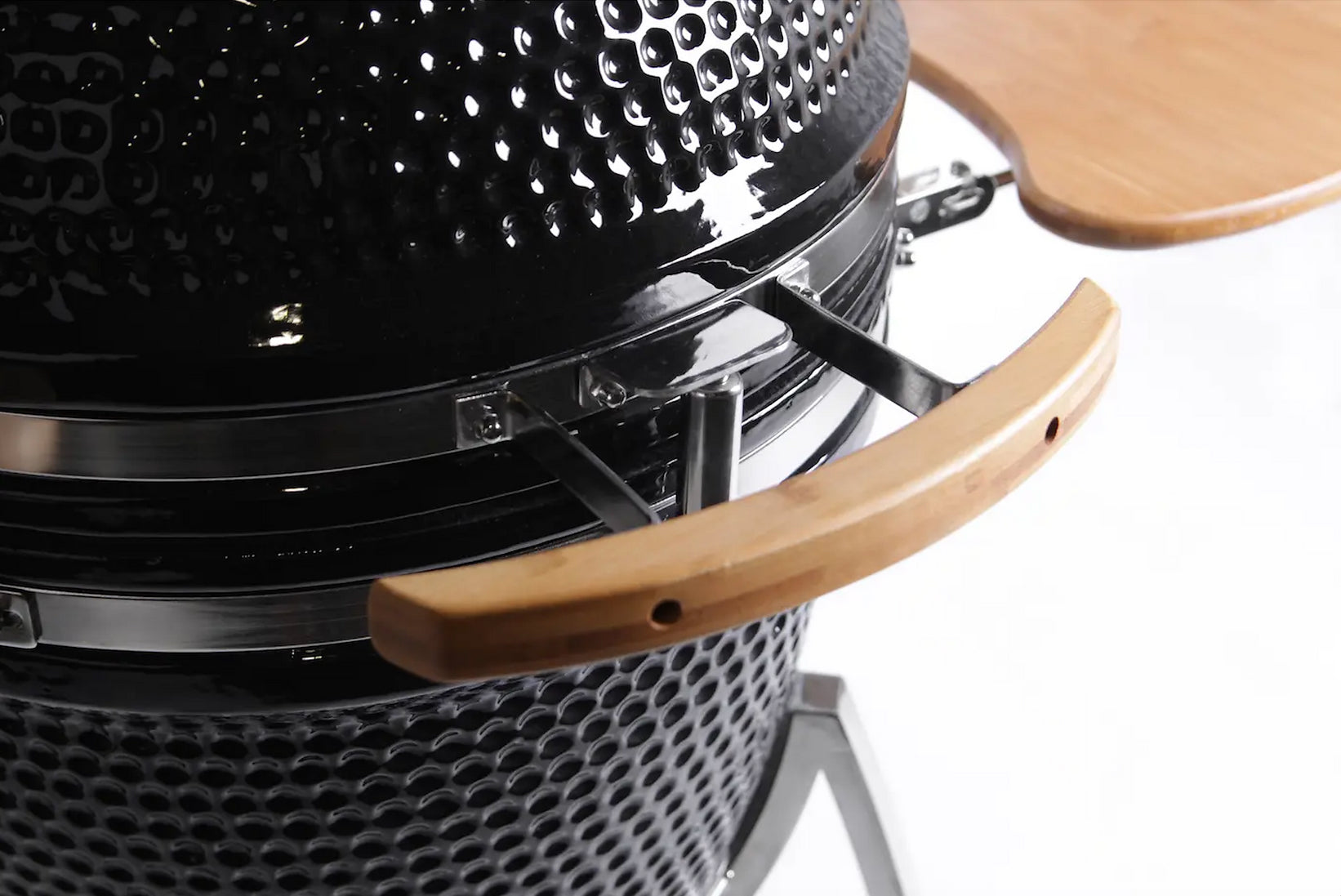 Close-up of a black barbecue grill with wooden handle on a white background