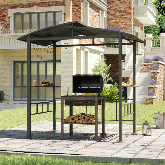 Outdoor gazebo with grill and firewood on a patio