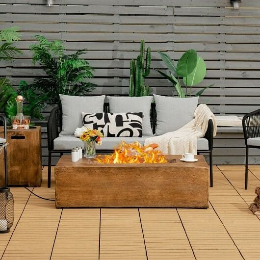 Outdoor patio with fire pit table, sofa, and decorative elements.