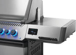 Stainless steel gas grill with control knobs and digital display on a white background