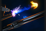 Welding process with sparks and flame on a dark background
