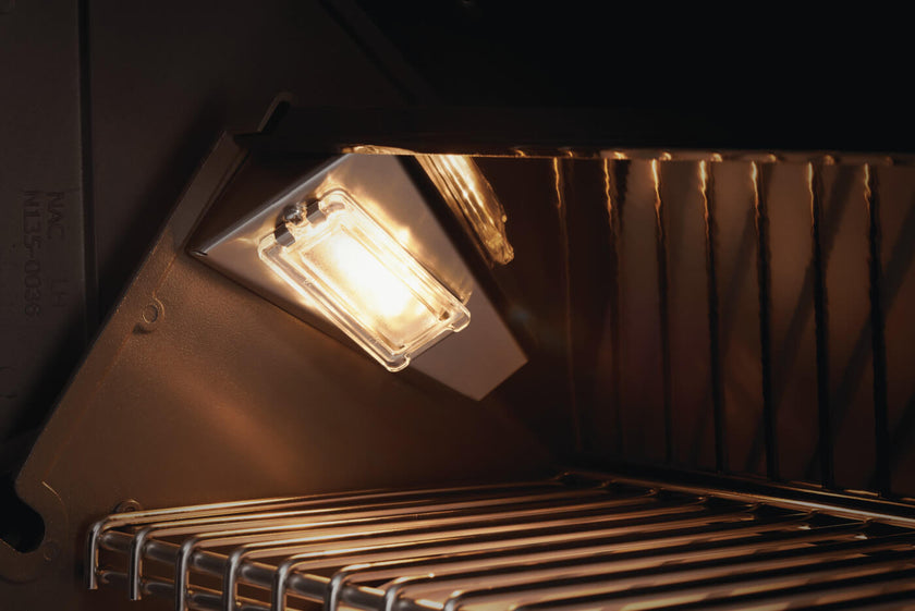 Light bulb inside a dark appliance, possibly an oven or microwave.