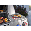 Stainless steel grill with food being cooked on a patio
