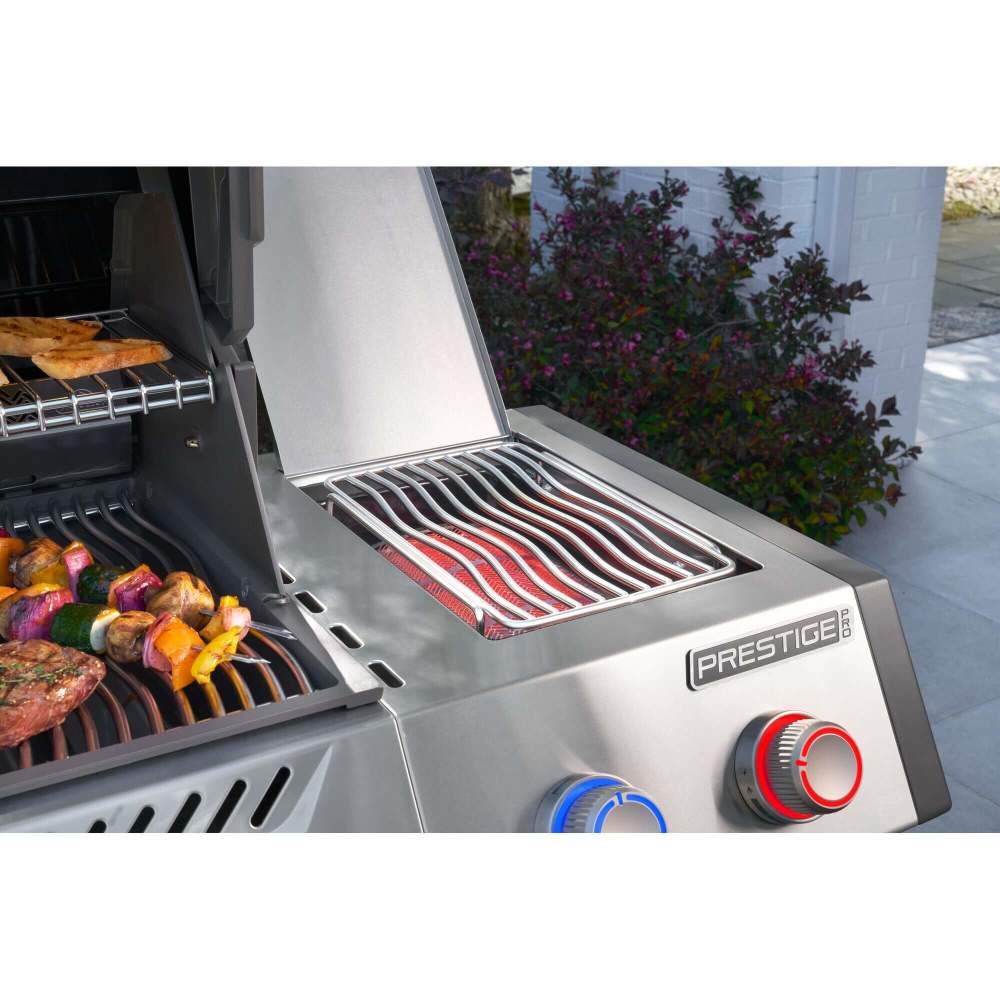 Stainless steel grill with food being cooked on a patio