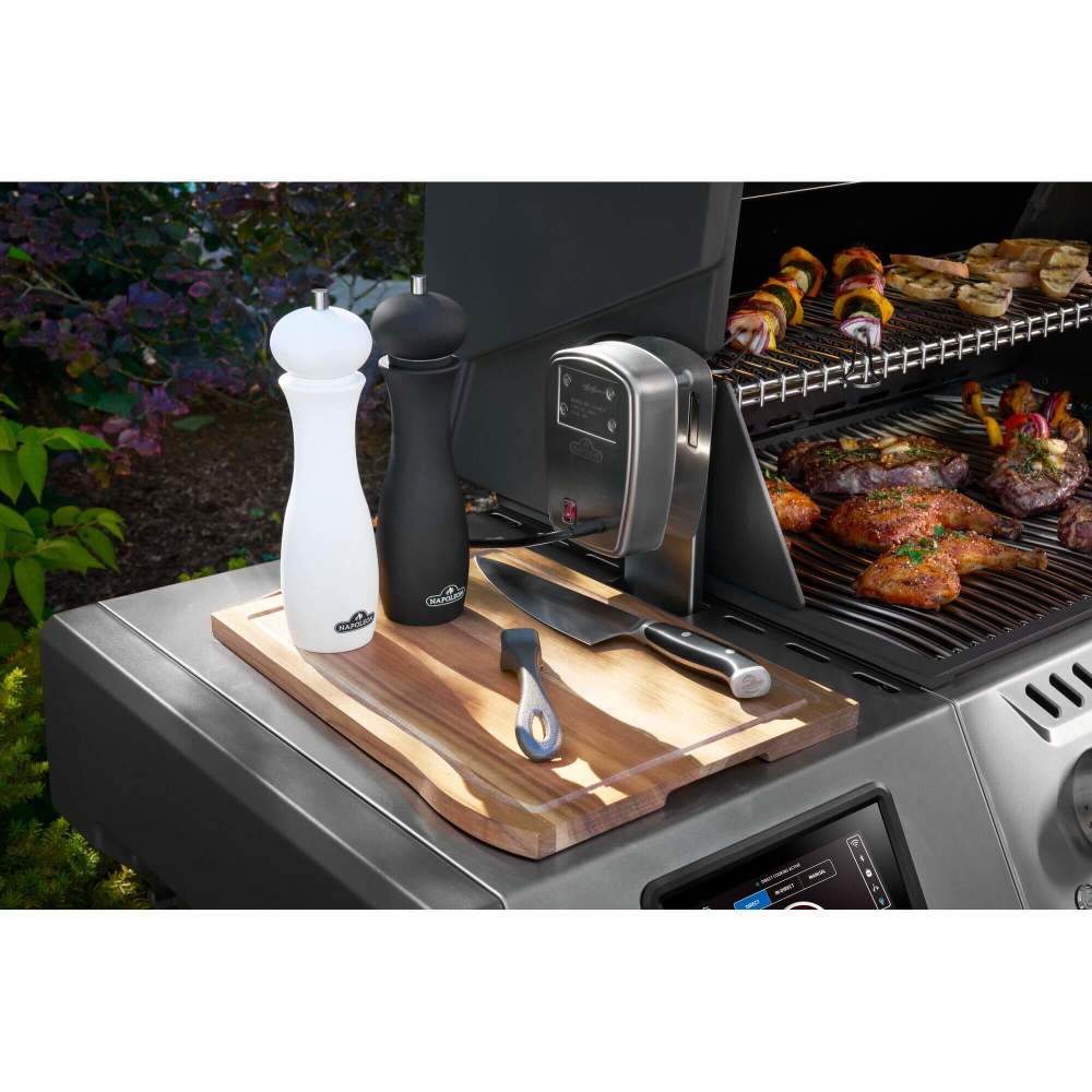 Grill with cutting board, knives, and seasoning shakers on a barbecue scene