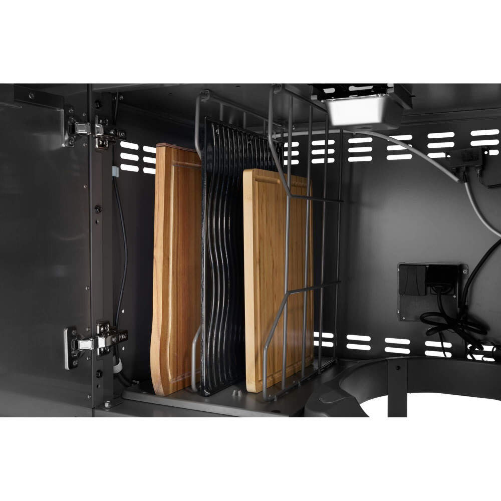 Close-up of a kitchen cabinet with wooden cutting boards and black knives inside.