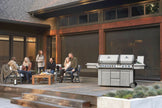 Family gathered around a barbecue grill on a patio