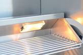 Stainless steel grill with glowing interior and metal grate