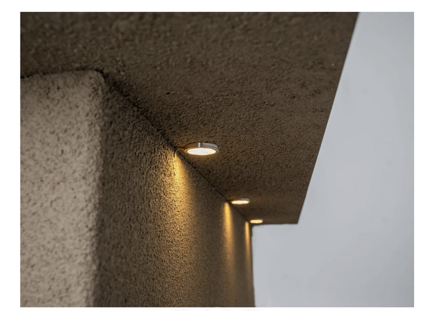 Modern outdoor light fixture embedded in a concrete wall.