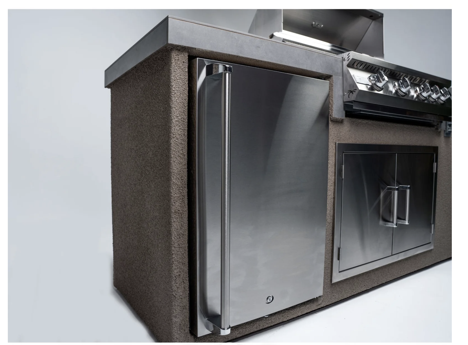 Stainless steel outdoor kitchen equipment with a refrigerator and grill on a gray background