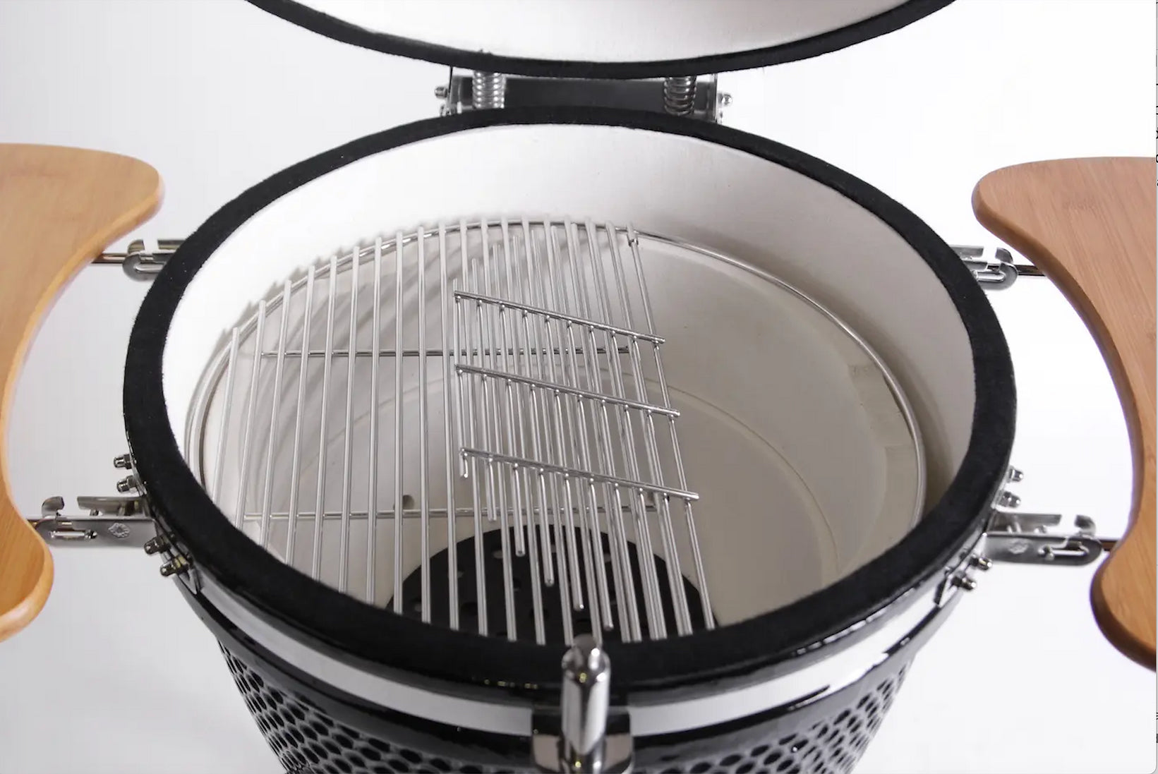 Close-up of a barbecue grill with a lid open, showing the interior.