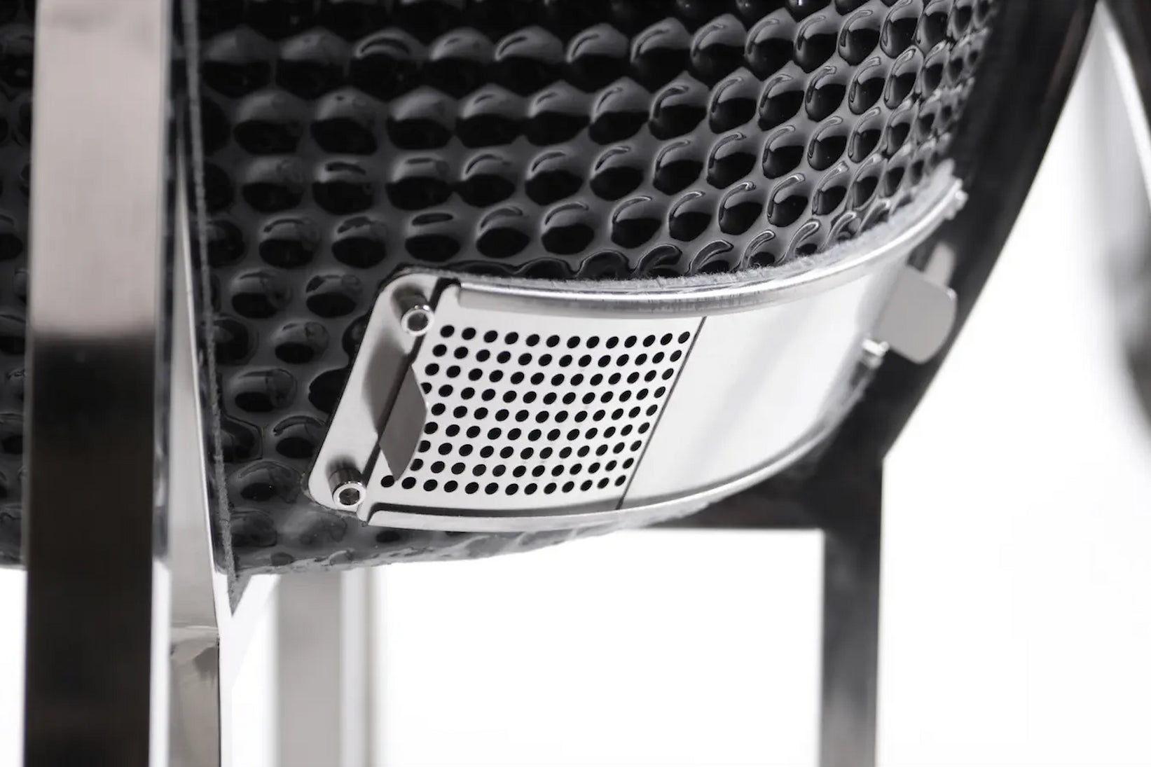 Close-up of a car grille with a honeycomb pattern on a white background
