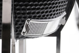 Close-up of a car grille with a honeycomb pattern on a white background