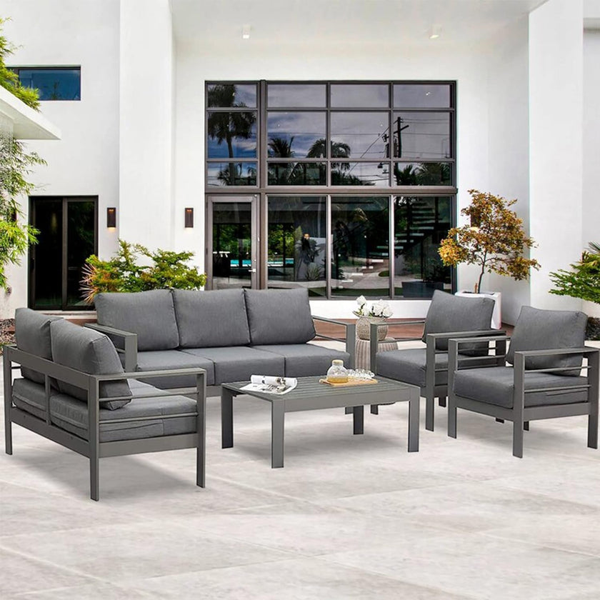 Gray outdoor furniture set on a patio with a building in the background