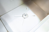 Close-up of a white kitchen sink with a light fixture above it.