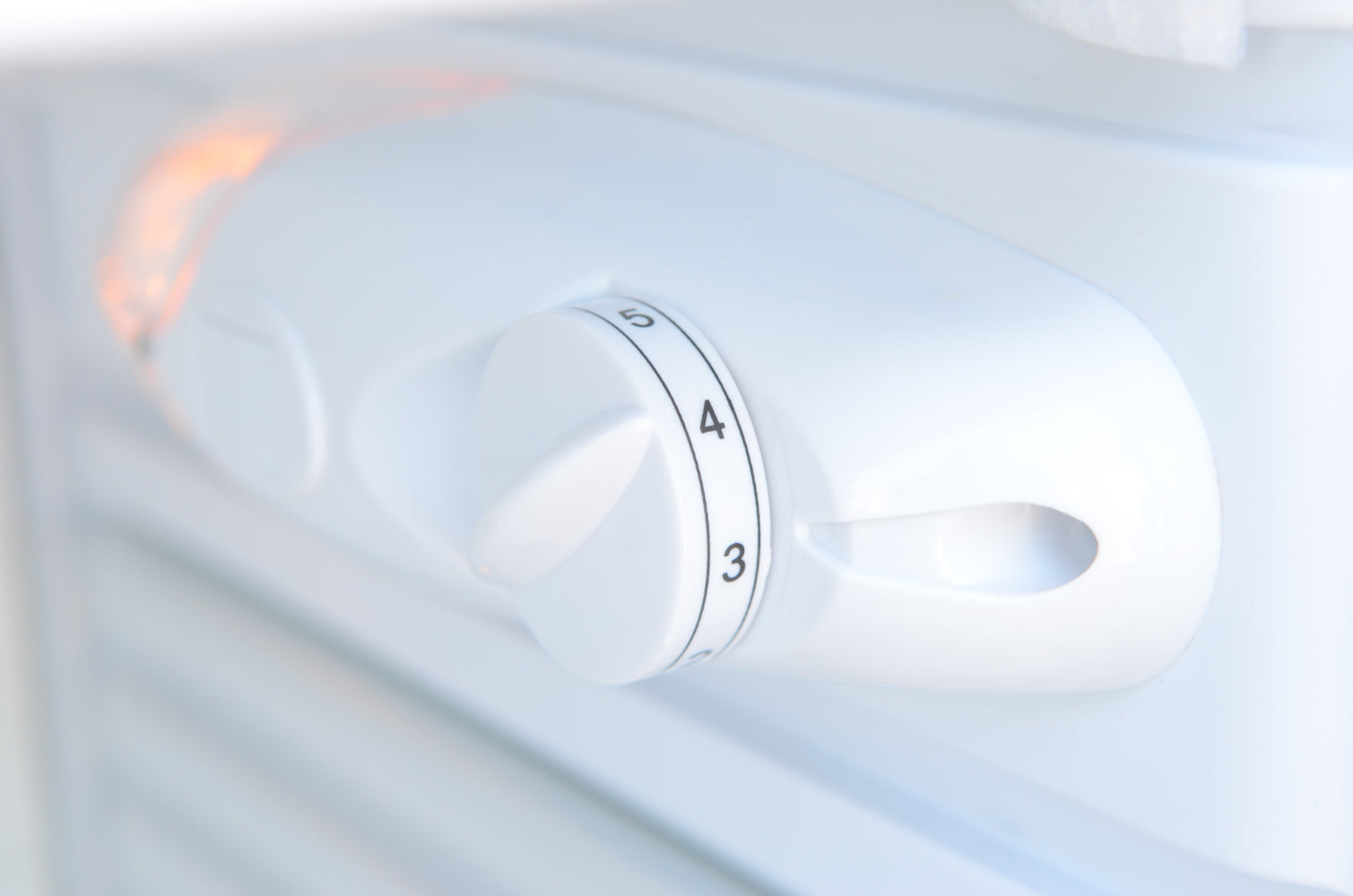 Control knob on a white appliance with numbers
