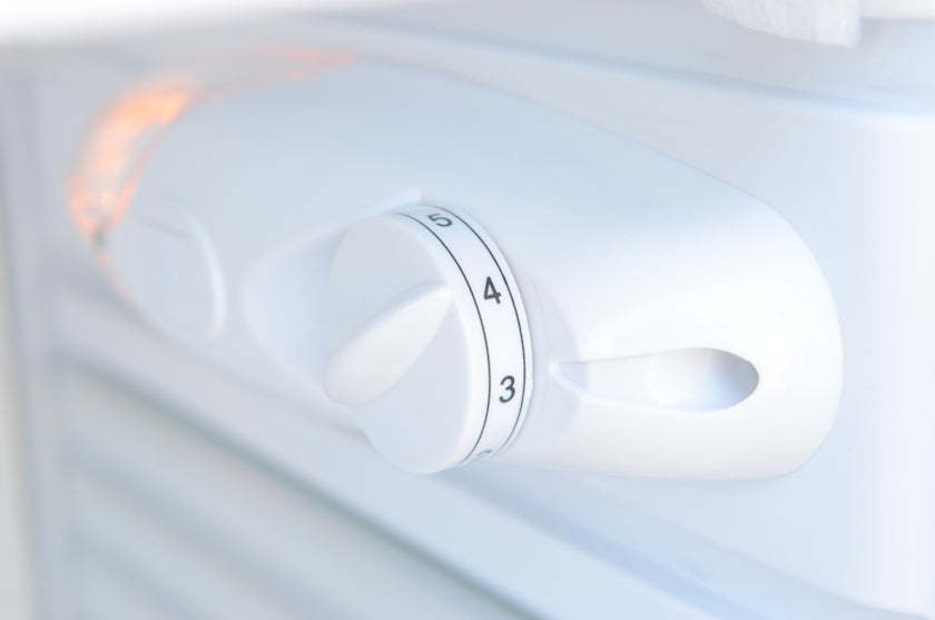Control knob on a white appliance with numbers